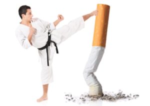 Karate man hitting a cigarette butt isolated against white background